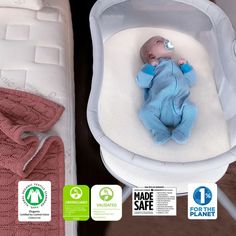 a baby laying in a crib next to a mattress