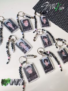 a bunch of key chains with pictures hanging from it's sides on a table