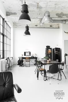 an industrial style kitchen and dining room are featured in this black and white photo