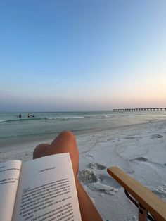 someone is reading a book on the beach