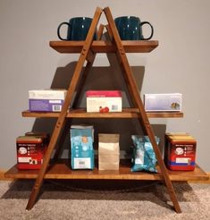 a wooden shelf filled with boxes and cups on top of carpeted floor next to wall