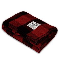 the red and black plaid blanket is folded on top of each other, with a white tag