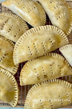 homemade empanas on a cooling rack ready to be baked in the oven for consumption