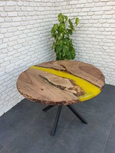 a wooden table sitting on top of a tile floor next to a white brick wall