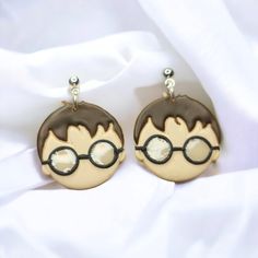 two brown and white earrings with harry potter glasses on them