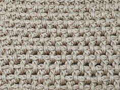 close up view of the crochet pattern on an afghan or rug that is knitted