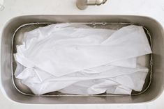 a metal sink filled with lots of white sheets