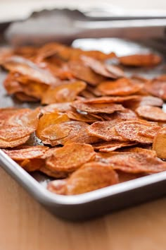 a pan filled with potato chips on top of a wooden table