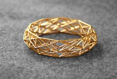 "This is the sleek version of the original Constructionist bracelet. This 3D printed goldplated bracelet is approx 2cm 0,8in) high, more subtle than the original version (see my other listing).  This 3D printed Constructionist bracelet was inspired by modern architecture and its use of complex repetitive geometrical structures. I am fascinated by how these structures can behave to create buildings and objects that look seemingly organic and unique, buildings that change their appearance dependin Parametric Jewelry, Wrapping Tutorial, 3d Jewelry, 3d Printed Jewelry, Geometric Bracelet, Gold Armband, Gold Rings Fashion, Bangles Jewelry Designs, Gold Bangles Design