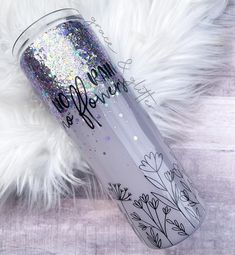 a white and silver glitter tumbler sitting on top of a fur rug