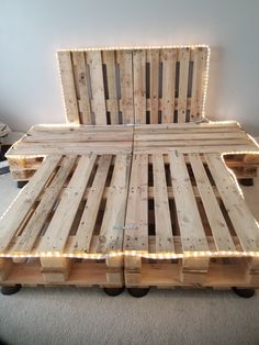 a bed made out of wooden pallets with lights