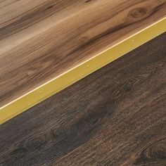 a close up view of some wood flooring with yellow trim on the bottom edge