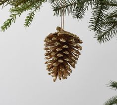 a pine cone ornament hanging from a christmas tree