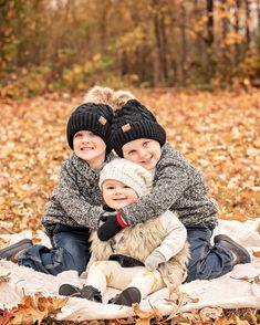 two children sitting on a blanket in the leaves