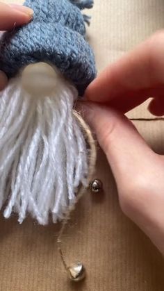 someone is working on an ornament made out of yarn and wool with beads