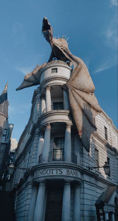 an old building with a giant dragon statue on top