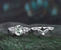 two wedding rings sitting on top of a green marble slab with diamonds in the middle