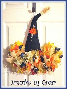 wreaths by gramm hanging on the front door with an orange and yellow witch's hat