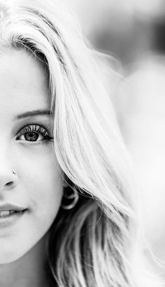 a black and white photo of a woman's face with long, blonde hair