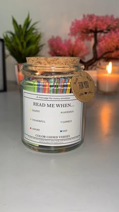 a jar filled with candles sitting on top of a table next to a potted plant