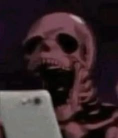 a skeleton holding an electronic device in its hand and looking at it's screen