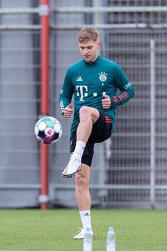 a man kicking a soccer ball on top of a field