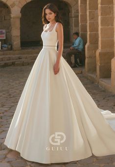 a woman in a white wedding dress standing outside