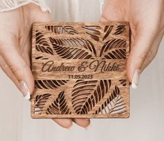 two hands holding a wooden wedding card