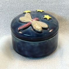 a small blue box with yellow stars and a dragonfly on it's lid