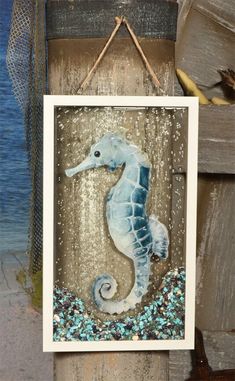 a sea horse is hanging on a wooden post