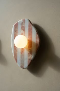 a candle is lit on the wall next to a plate that has stripes on it