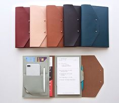 an assortment of notebooks and stationery items laid out on top of each other