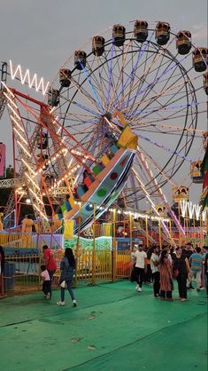 an amusement park with several rides and people walking around