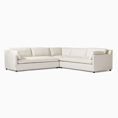 a white sectional couch sitting on top of a white floor