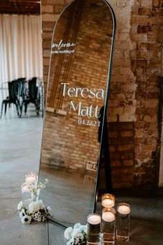 a large mirror sitting on top of a table next to candles