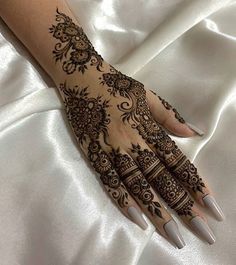 a woman's hand with henna tattoos on it