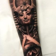 an egyptian tattoo on the arm of a woman with black and grey lines around her face