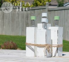 three bottles wrapped in twine and tied with rope on top of a wooden table