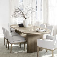 a dining room table with white chairs around it