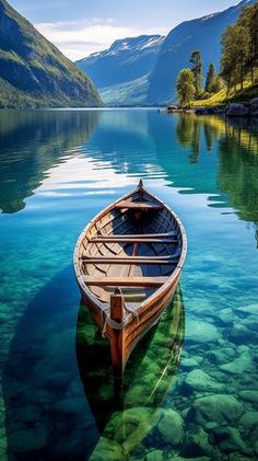 a boat floating on top of a lake surrounded by mountains