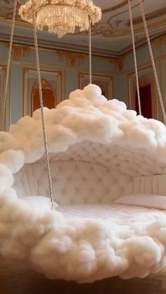 a suspended bed made out of clouds in a room with chandelier hanging from the ceiling