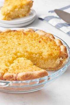 a pie sitting on top of a table next to a plate with a slice missing