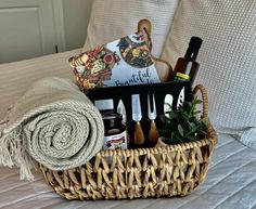 a wicker basket filled with kitchen utensils and other items on a bed