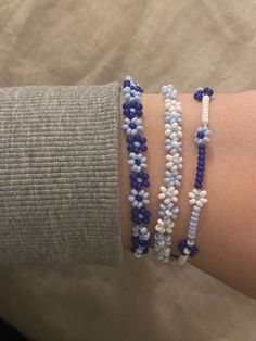 a woman's arm with three bracelets on top of each other, one beaded in blue and the other white