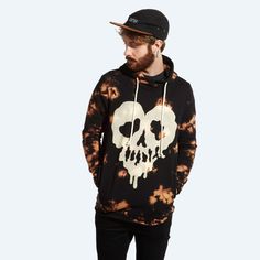 a man wearing a tie dye hoodie with a skull on it