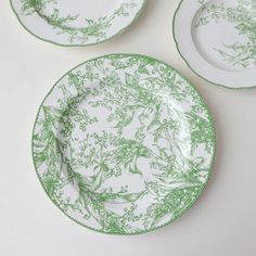 three green and white plates sitting on top of a table next to each other,