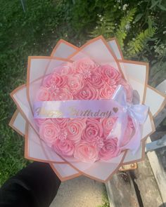 a bouquet of pink roses with a happy birthday ribbon on it in someone's hand