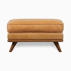 a tan leather ottoman sitting on top of a wooden frame legs and footrests