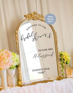 a mirror sitting on top of a table next to flowers