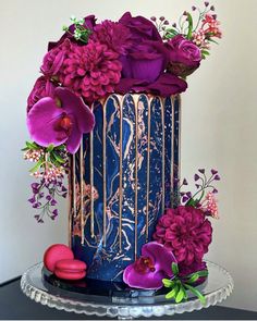 a blue and gold cake with purple flowers on top